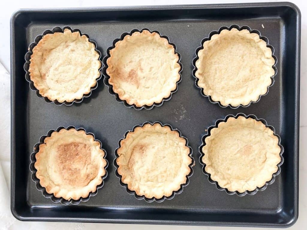 baked mini tarts on a baking sheet