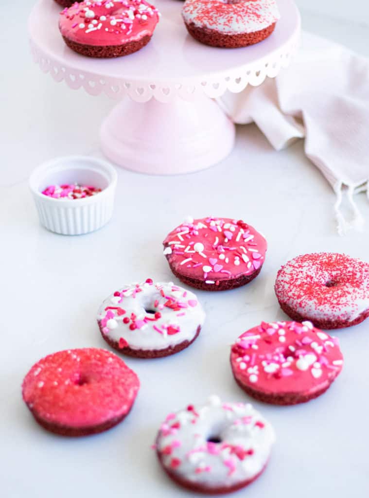 red and white donuts with sprinkles on a counter