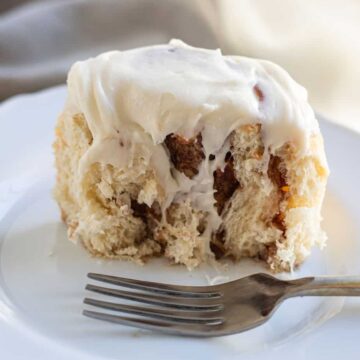 close up of apple cinnamon roll cut in half on plate