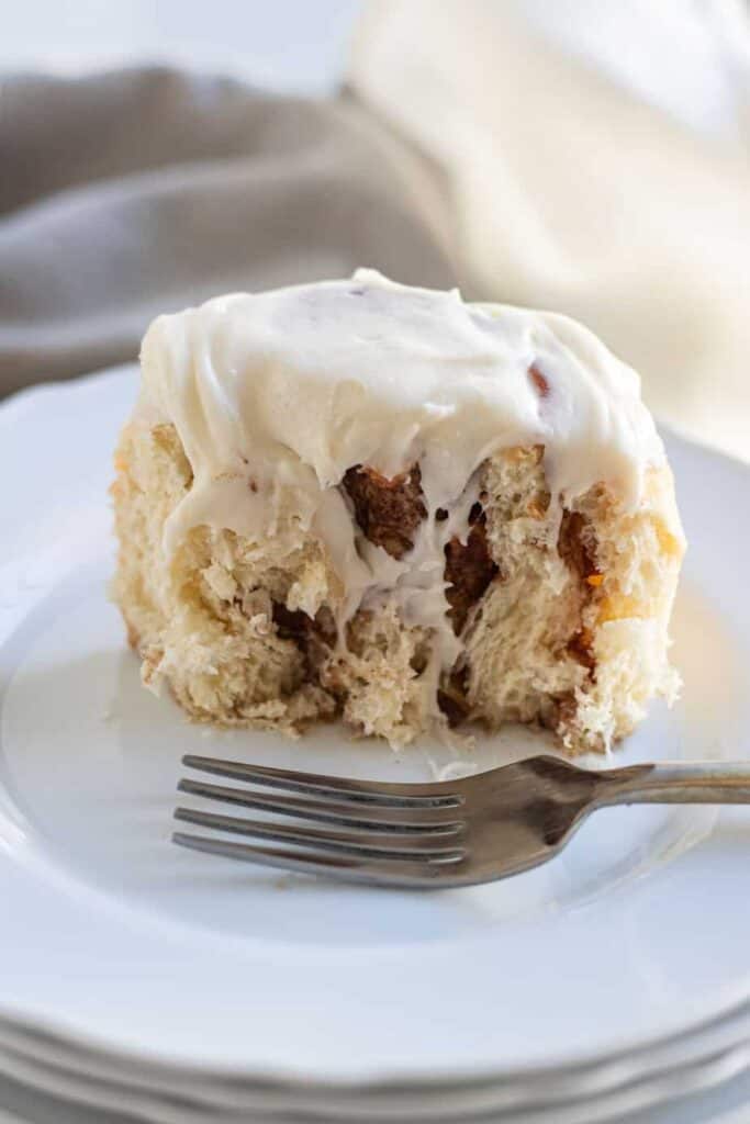 close up of apple cinnamon roll cut in half on plate