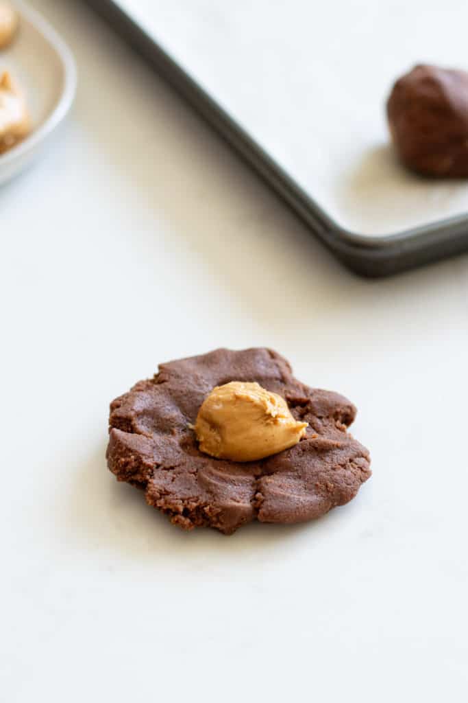 peanut butter ball on top of raw cookie dough