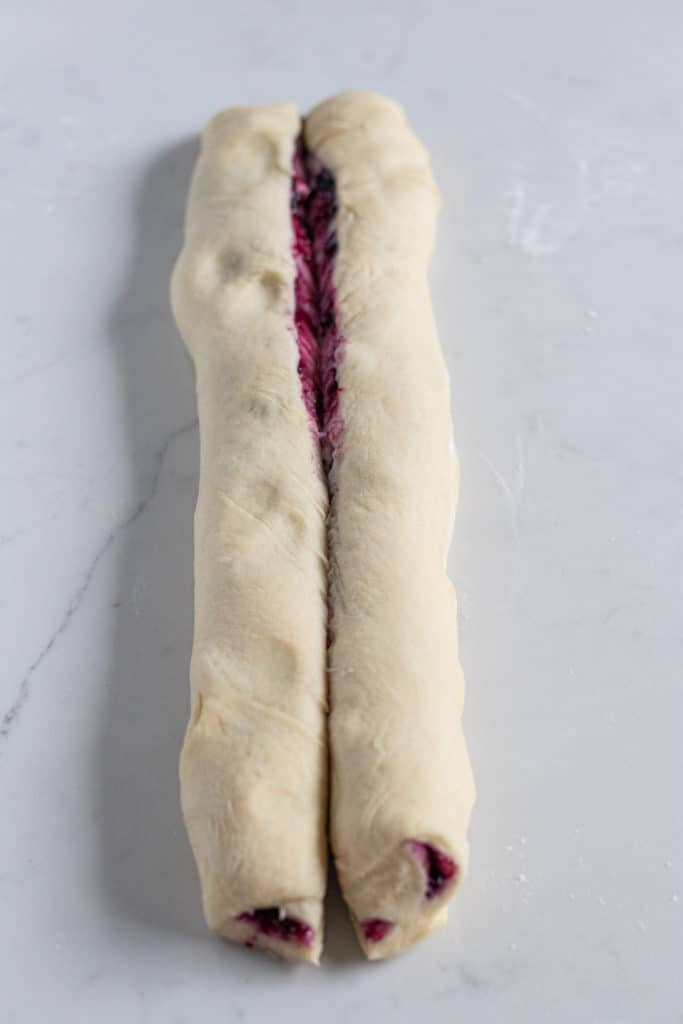 Rolled blueberry cream cheese babka dough cut in half