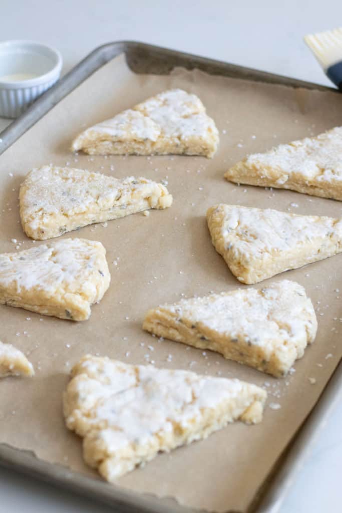 lavender scone dough cut in wedges on baking sheet
