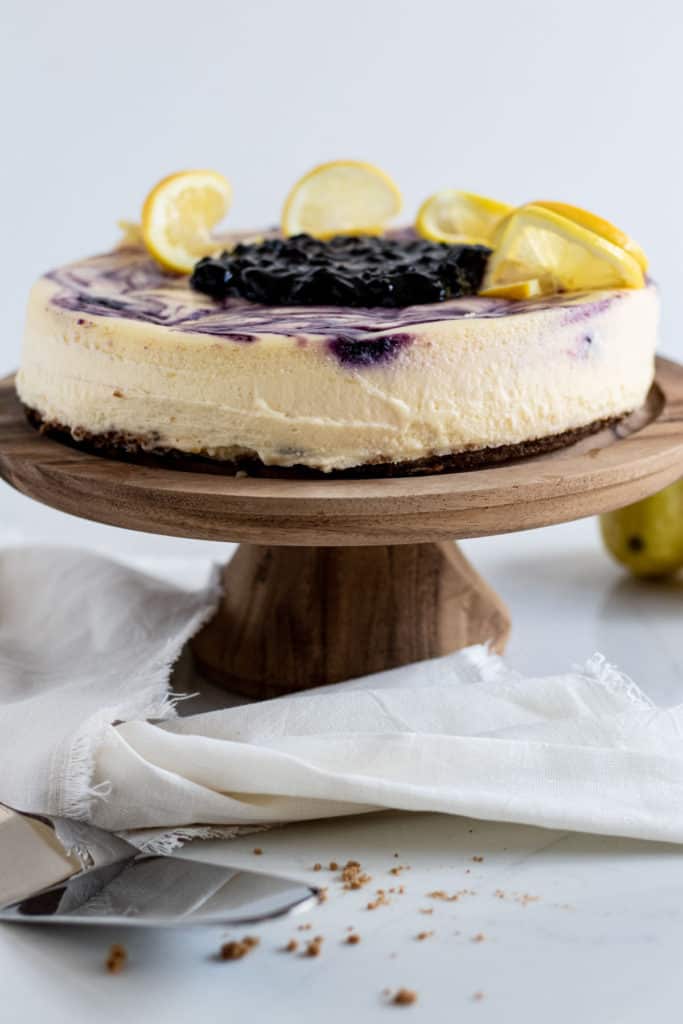 View of lemon blueberry cheesecake on cake pedestal