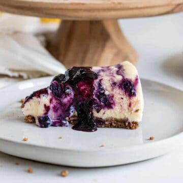 Slice of blueberry lemon cheesecake on plate