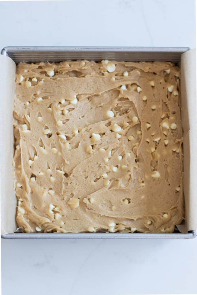 white chocolate blondie batter in a square pan