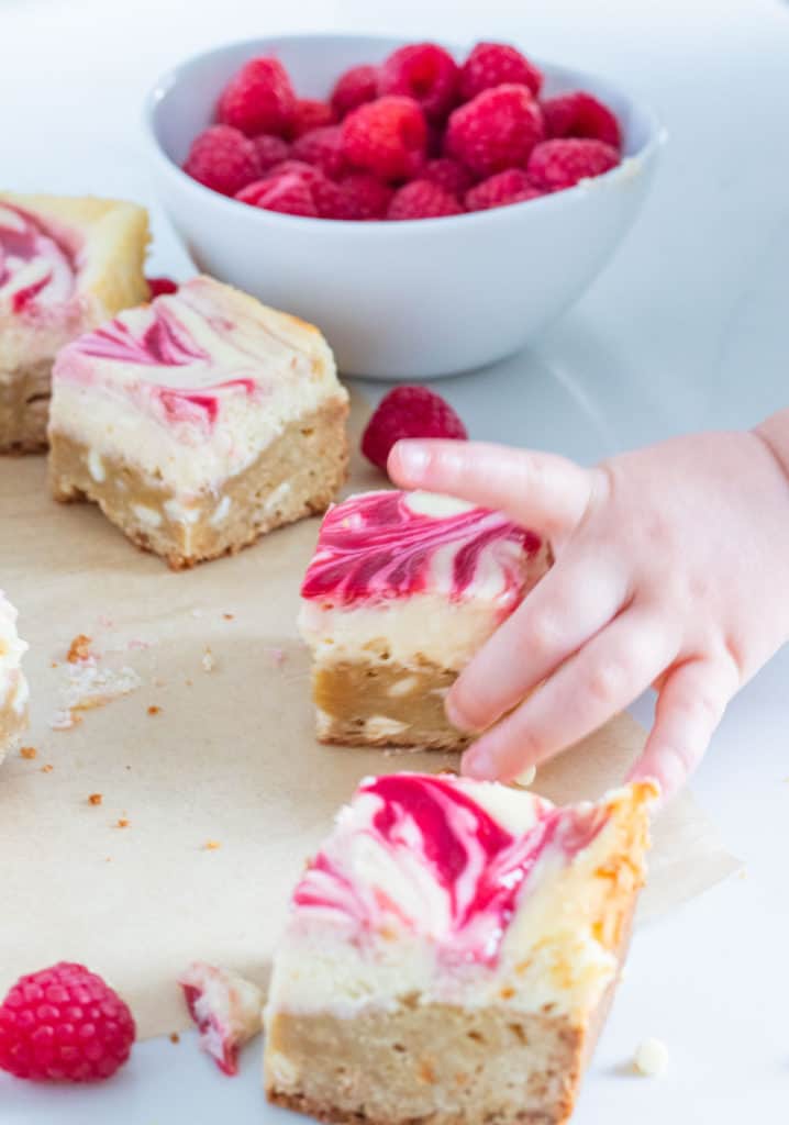 toddler hand reaching for a cheesecake bar