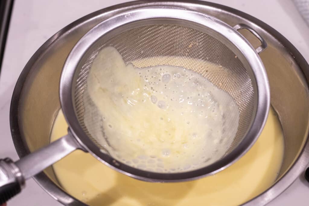 custard poured through fine mesh sieve