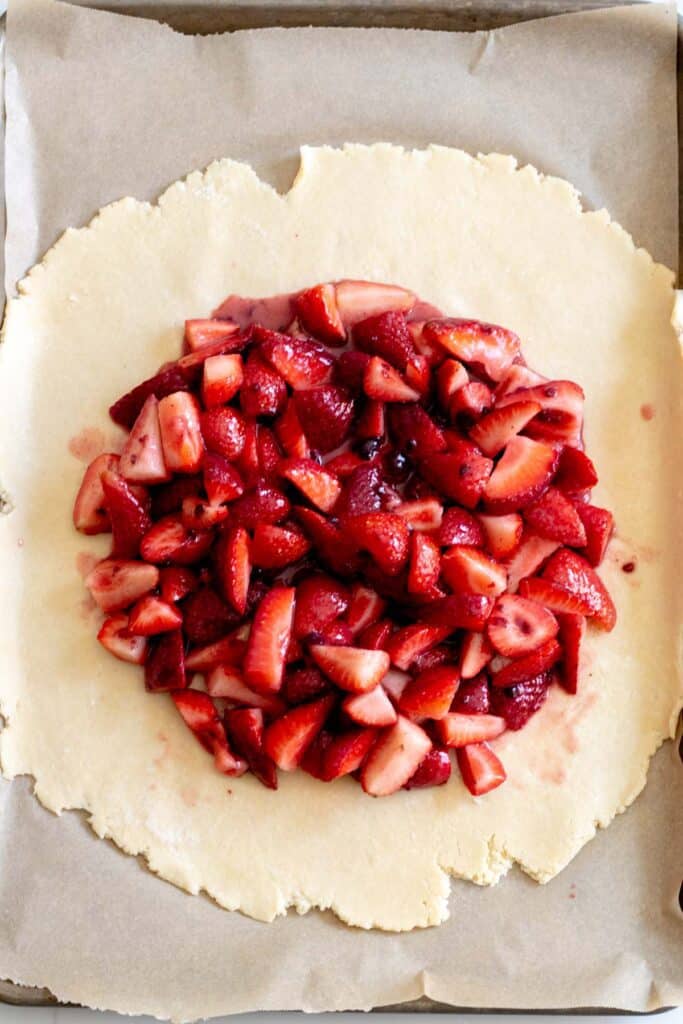 strawberries piled onto center of pie dough circle