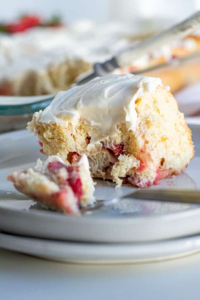 close up of a strawberry sweet roll with bite on fork