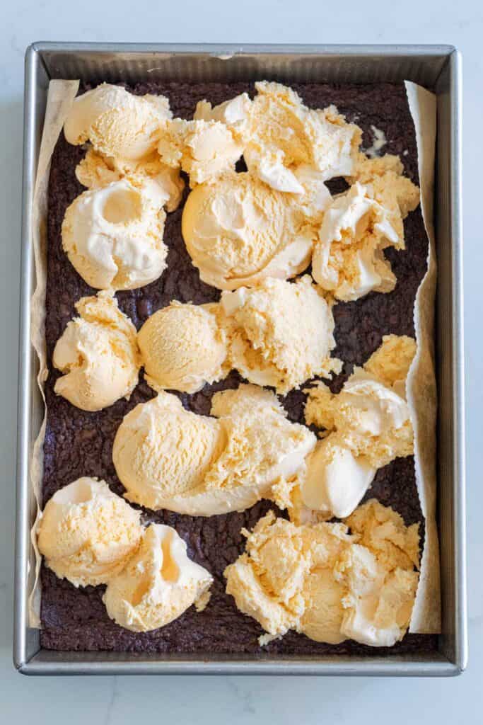 pan of brownies with vanilla ice cream scoops on top