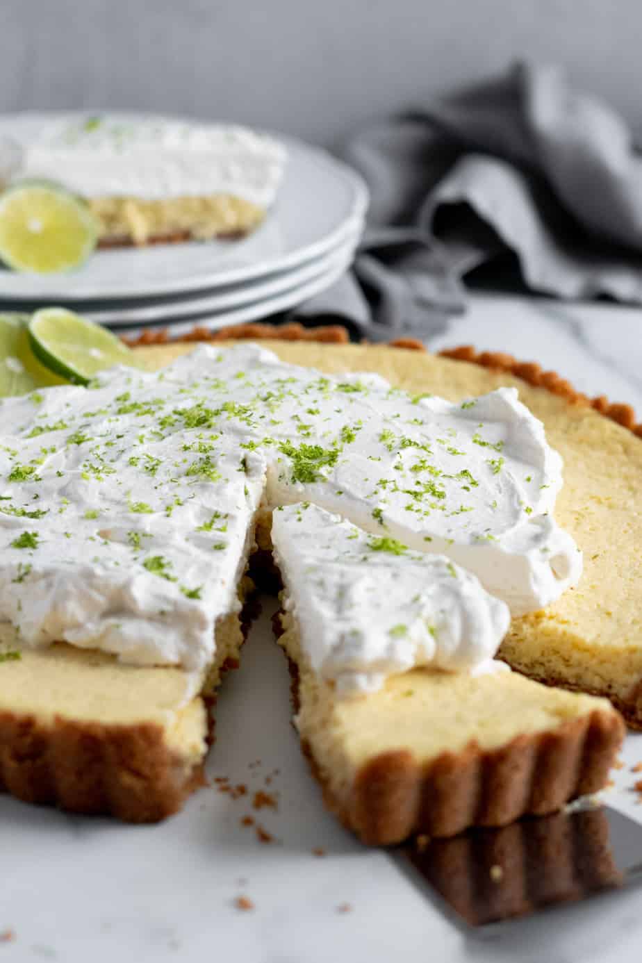 slice of key lime tart cut out of large tart