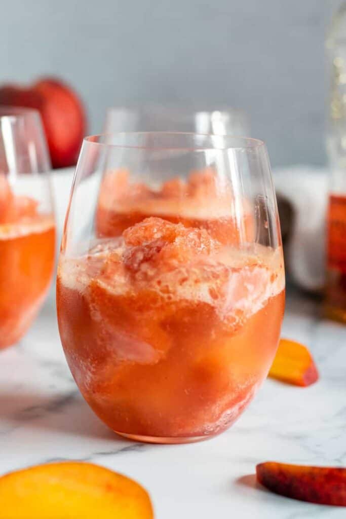 close up of a glass with peach bourbon slush