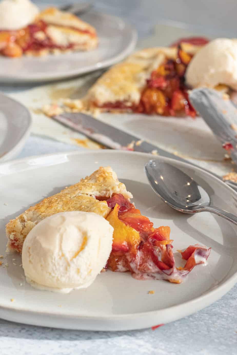 slice of peach galette on plate with vanilla ice cream