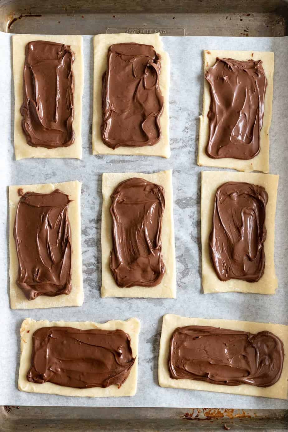 nutella spread on 8 dough rectangles on a baking sheet lined with parchment