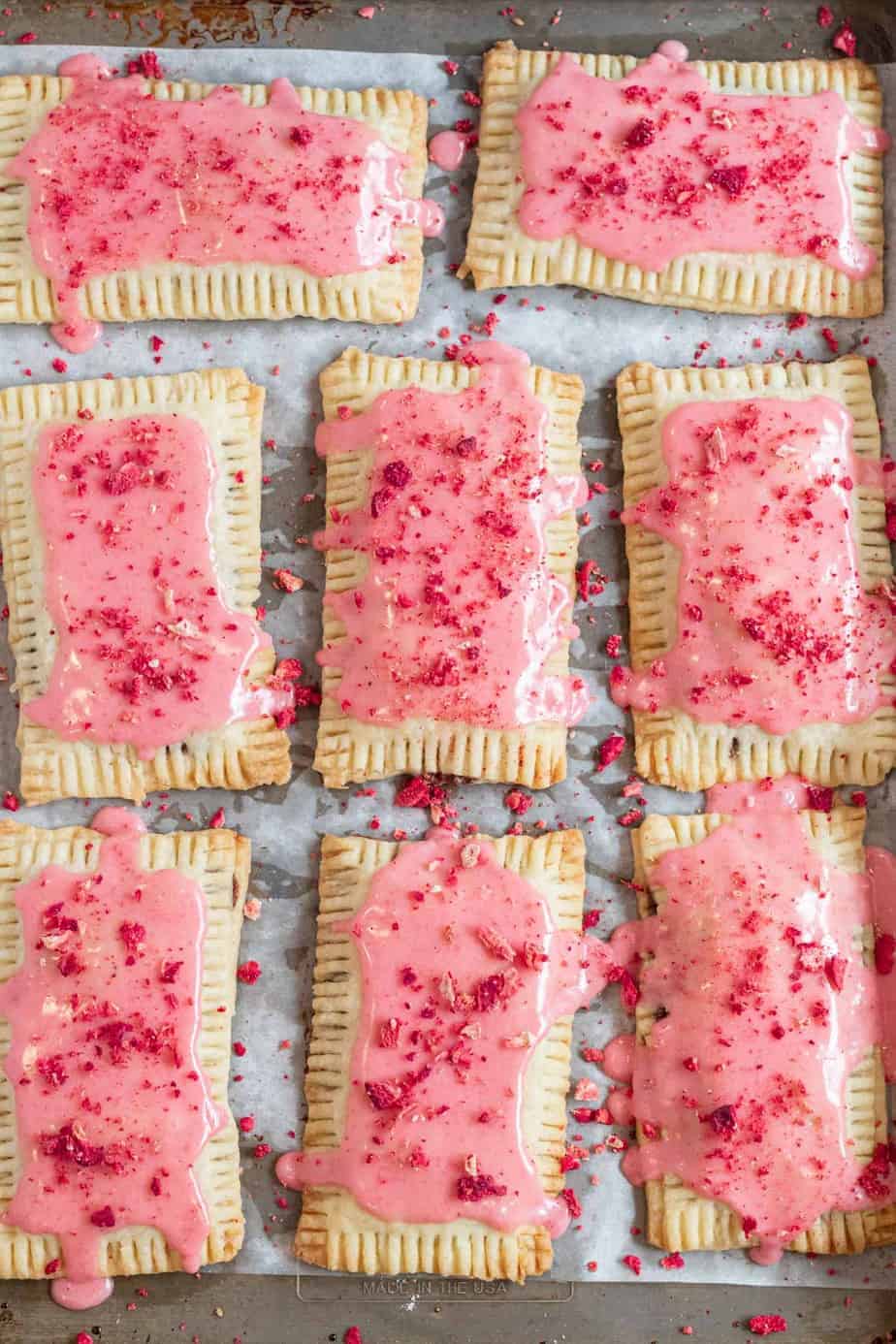 pop tarts with strawberry glaze on baking sheet