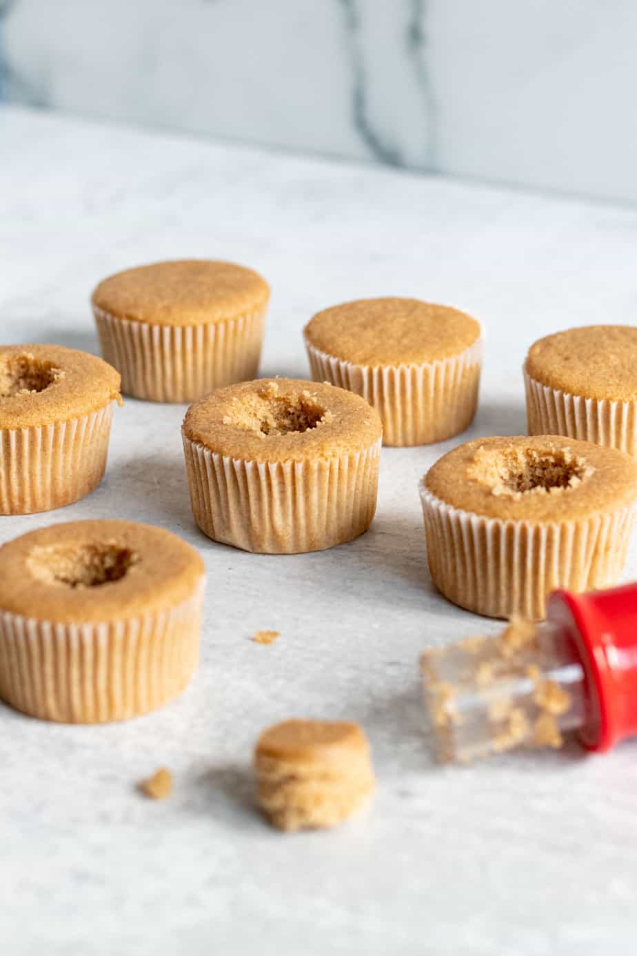 cupcakes with the middle of the cake cut out using a red cupcake corer