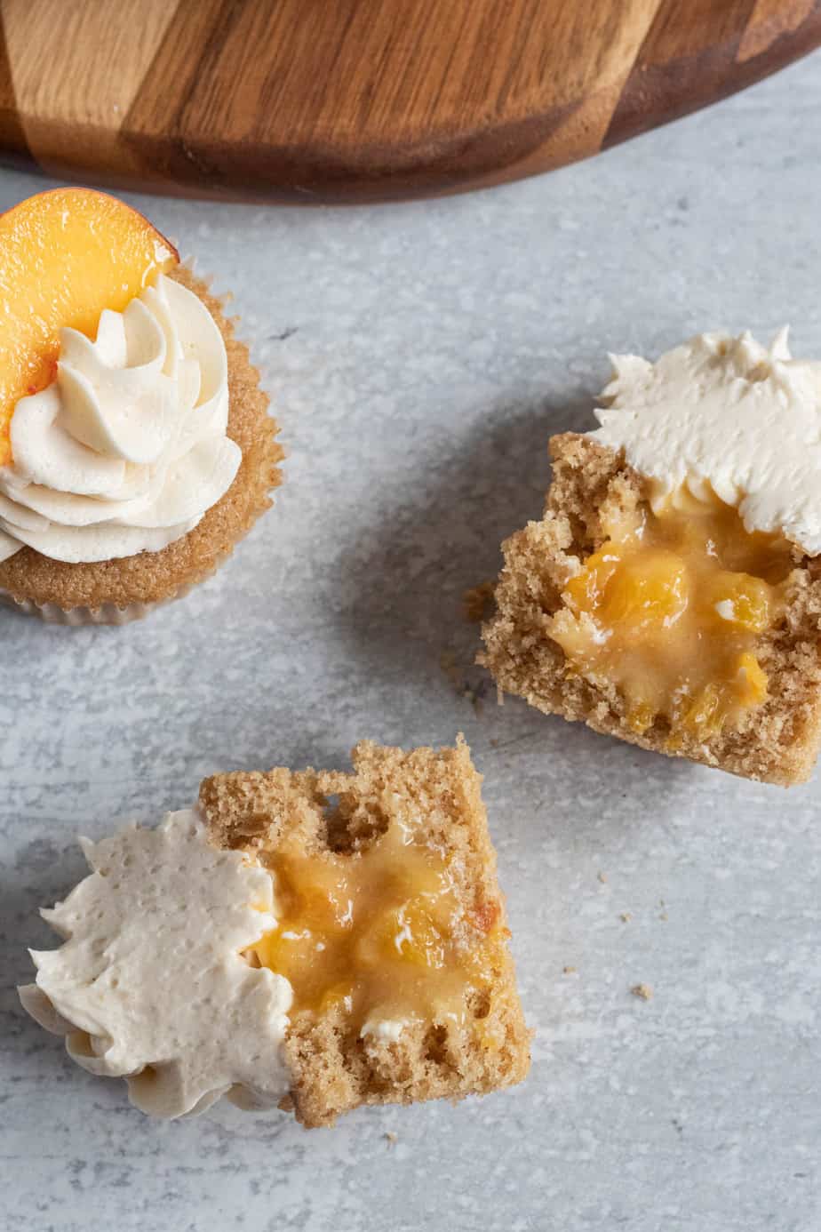 peach cobbler cupcake cut in half showing peach filling in the middle