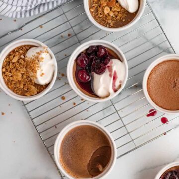 chocolate pots de cremes in white ramekins with pretzel crumble or bourbon cherries on top