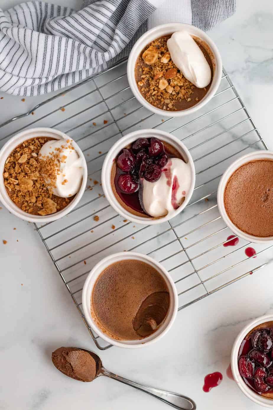 chocolate pots de cremes in white ramekins with pretzel crumble or bourbon cherries on top