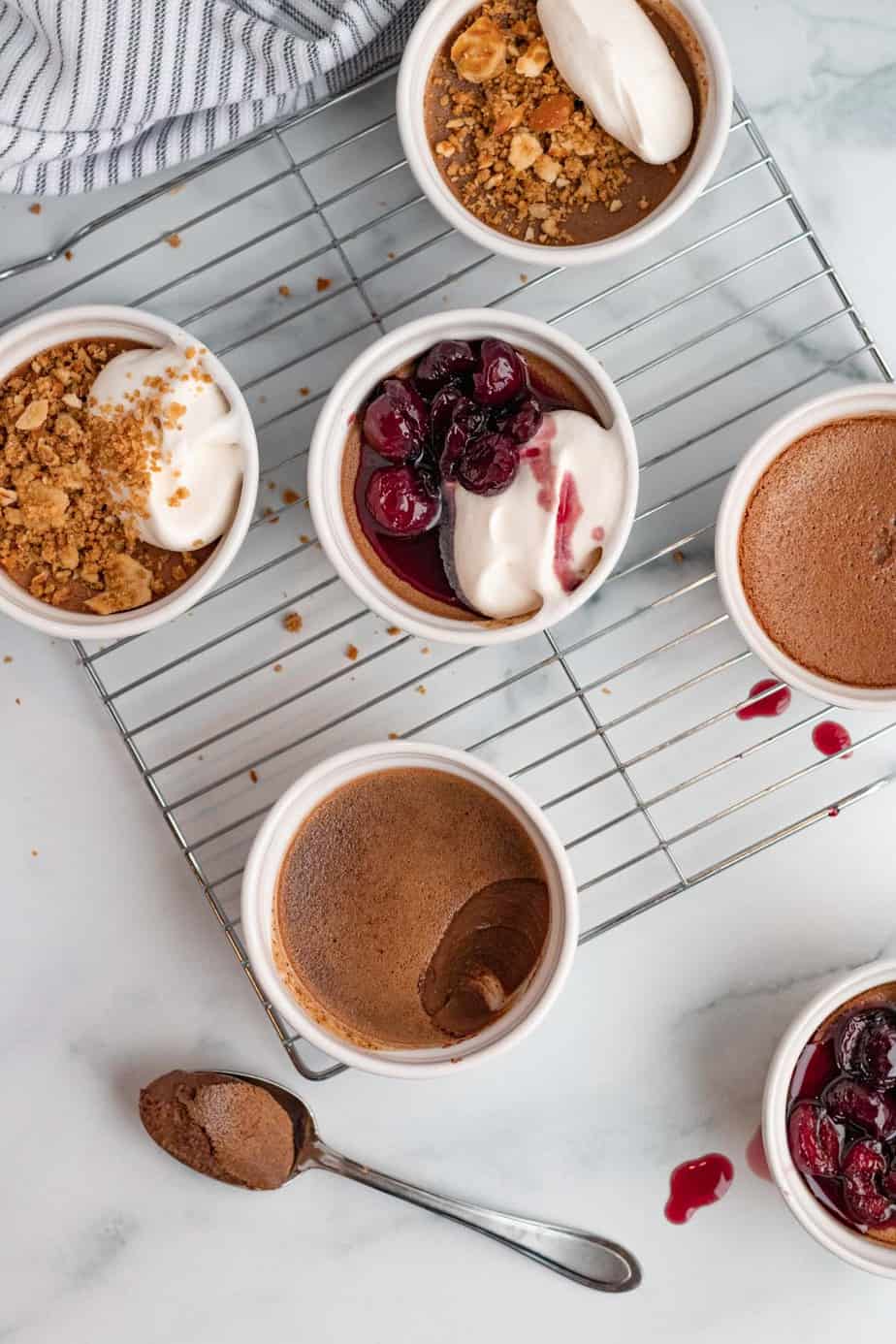 chocolate pots de cremes in white ramekins with pretzel crumble or bourbon cherries on top