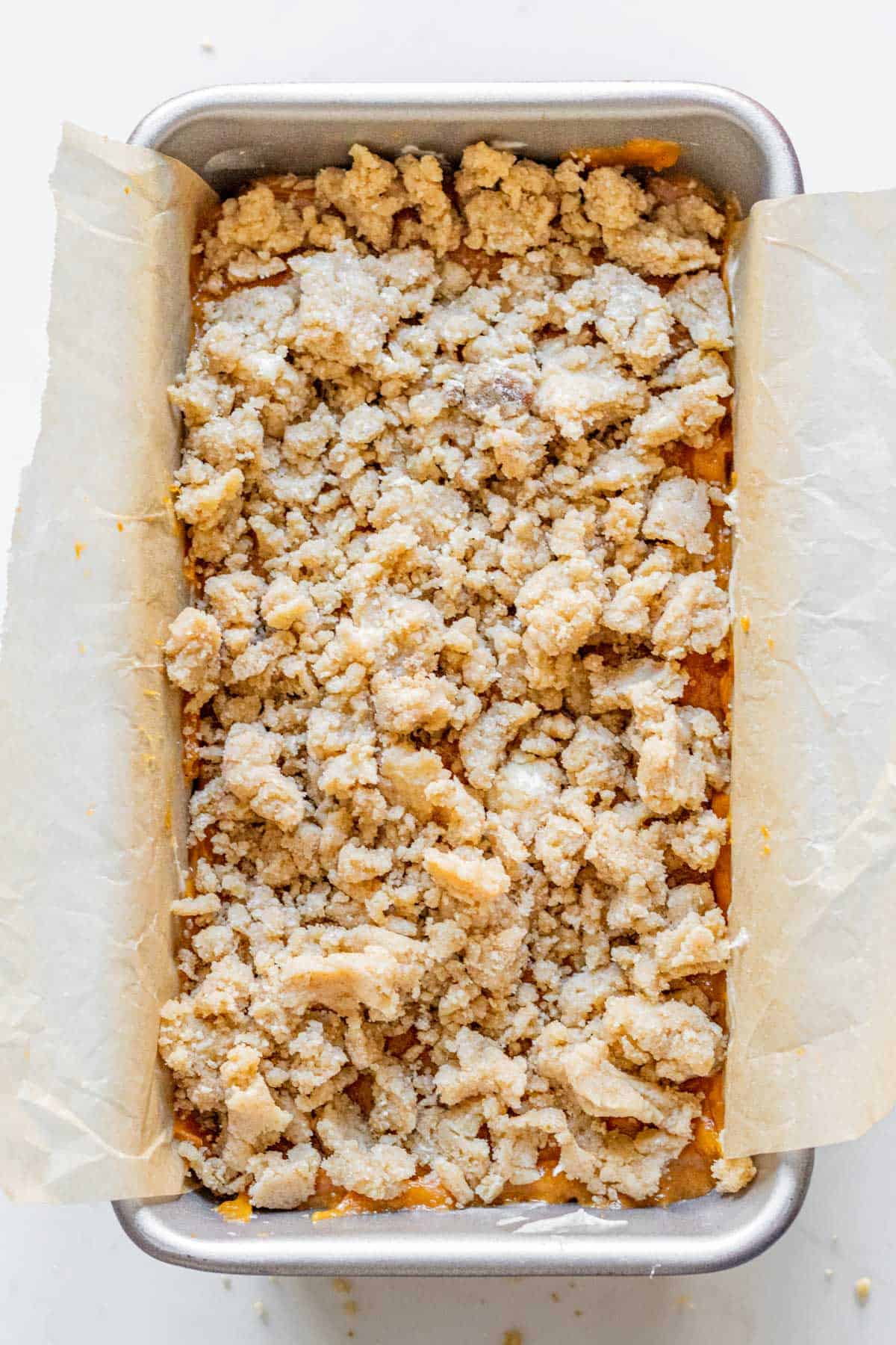 pumpkin bread batter with a streusel topping in a loaf pan