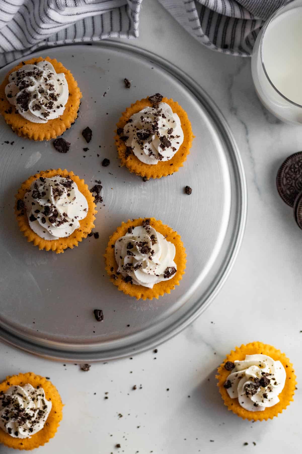 top view of 6 mini pumpkin cheesecakes with whipped cream and chocolate cookie crumbs