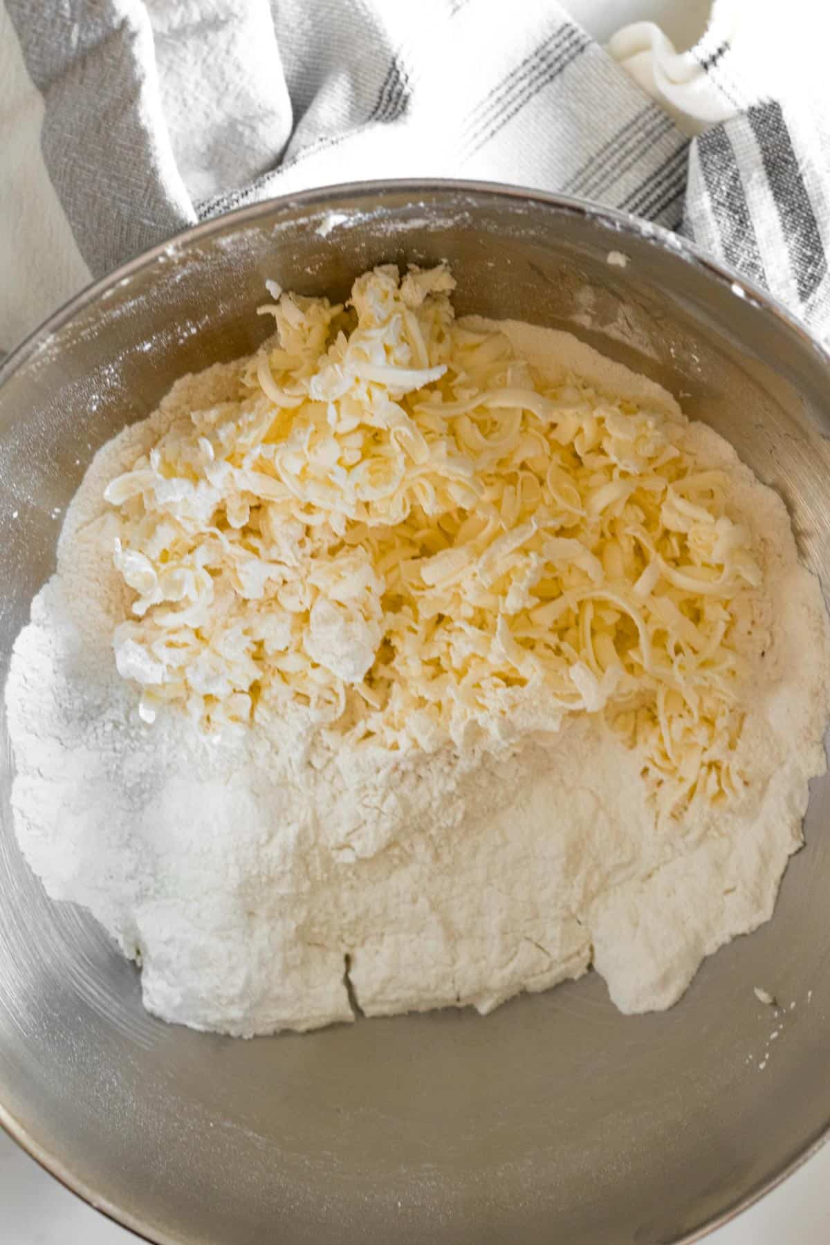 flour and grated butter in a silver mixing bowl