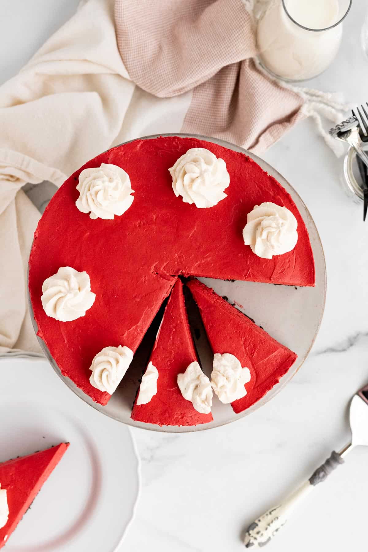 red velvet no-bake cheesecake with 2 slices cut and another slice on a white plate