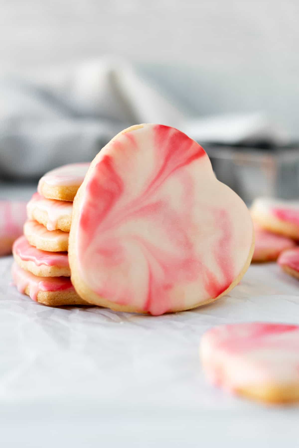 stack of heart shaped marbled sugar cookies with one cookie leaning against the stack