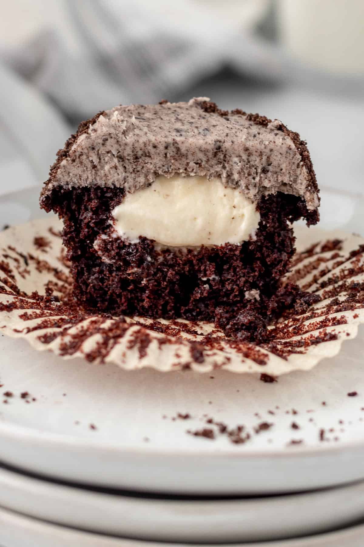 chocolate oreo cupcake split in half showing vanilla cream filling