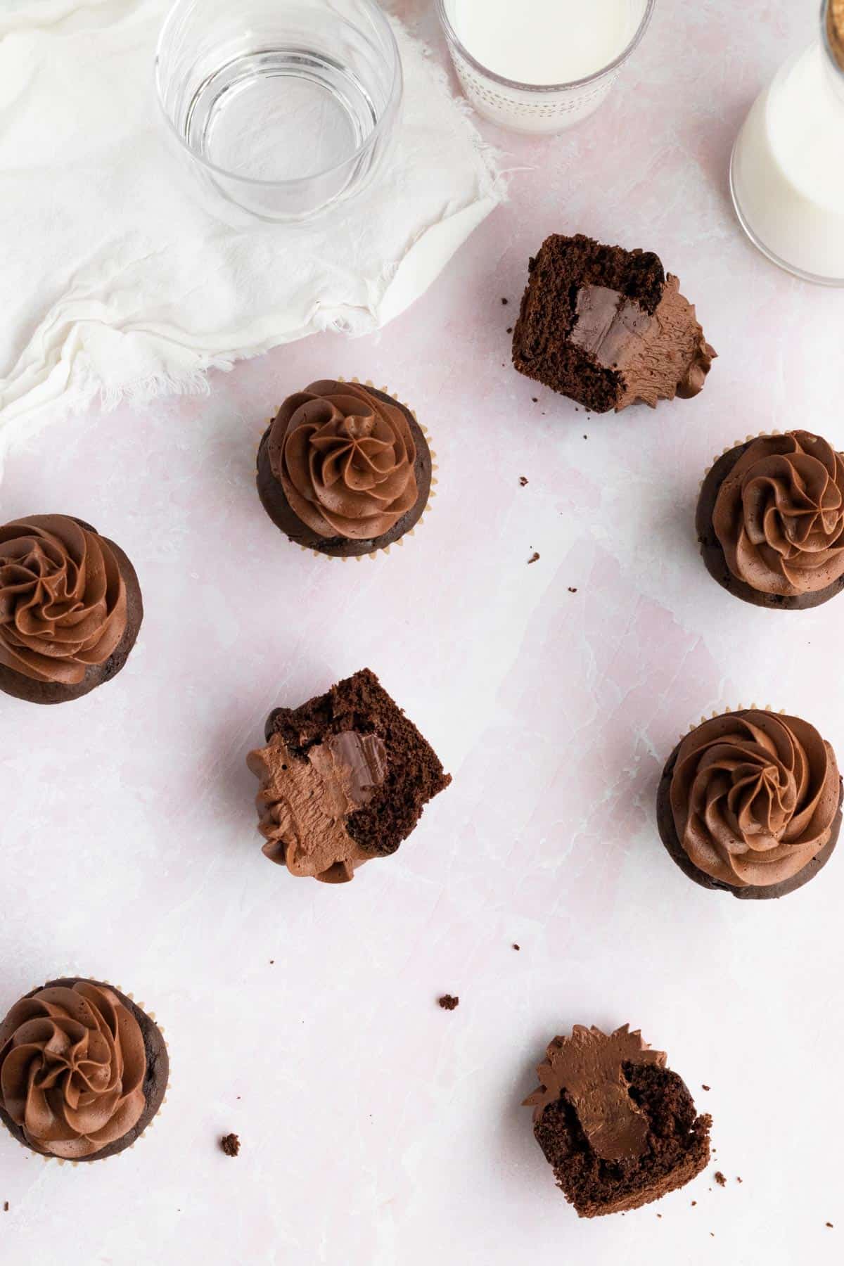 overhead view of triple chocolate cupcakes with one cupcake split in half to show chocolate filling