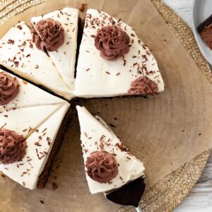 chocolate baileys cheesecake sitting on brown parchment paper with chocolate whipped cream swirls