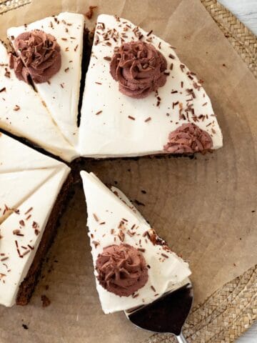 chocolate baileys cheesecake sitting on brown parchment paper with chocolate whipped cream swirls