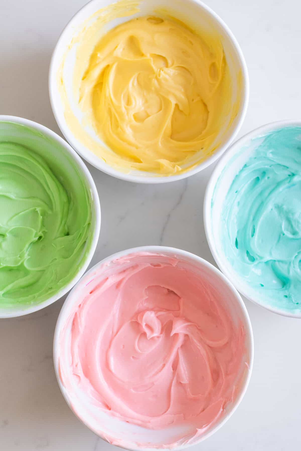 bowls of cream cheese filling dyed pastel colors