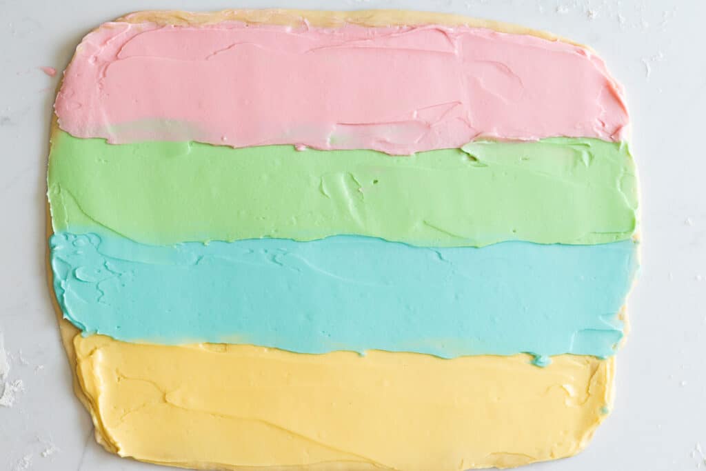 Babka dough rolled into a rectangle and spread with pastel colors in 4 horizontal lines