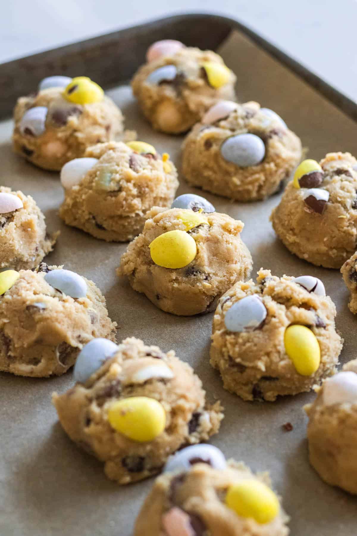 balls of cookie dough with mini egg candies on top