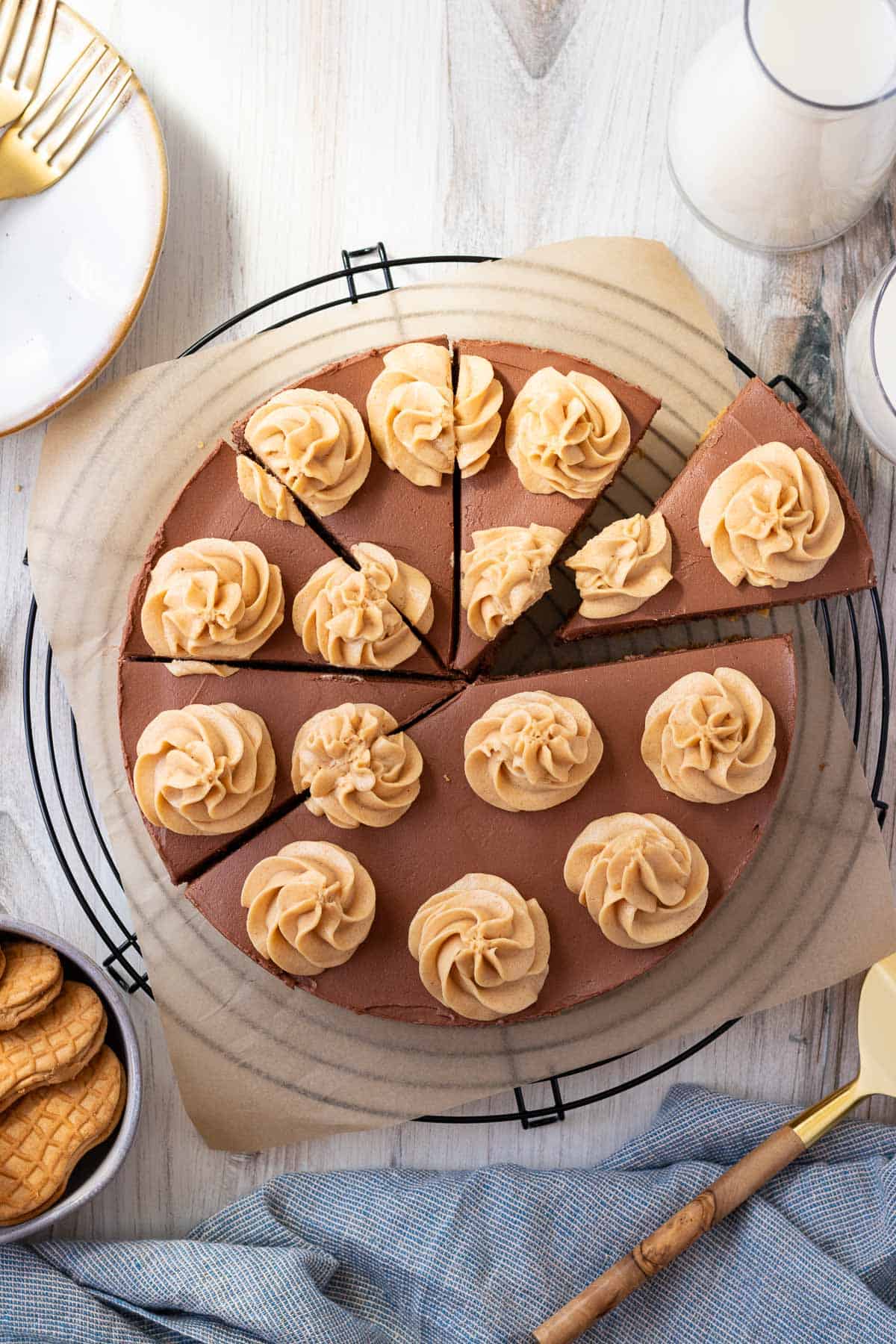 chocolate peanut butter cheesecake on top of a black wire cooling rack with a bowl of peanut butter cookies next to it