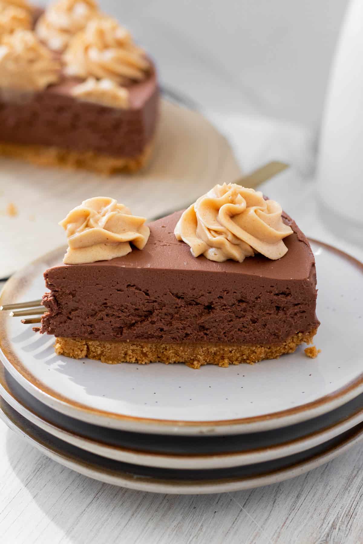 slice of chocolate peanut butter no-bake cheesecake on a white plate with a golf fork