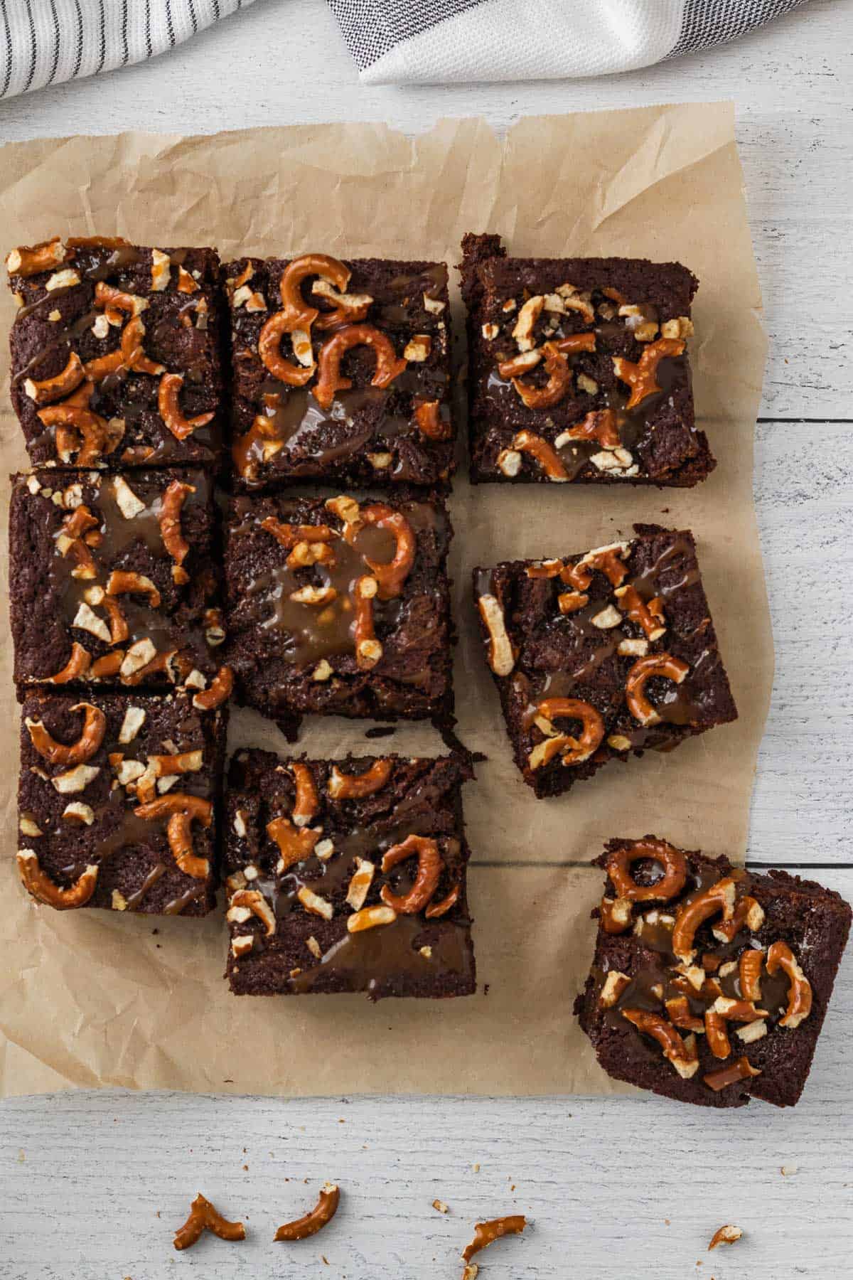 brownies topped with salted caramel and pretzels cut into squares