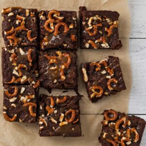 brownies topped with salted caramel and pretzels cut into squares