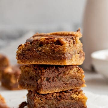 stack of 3 nutella blondies with white bowl and carafe in background