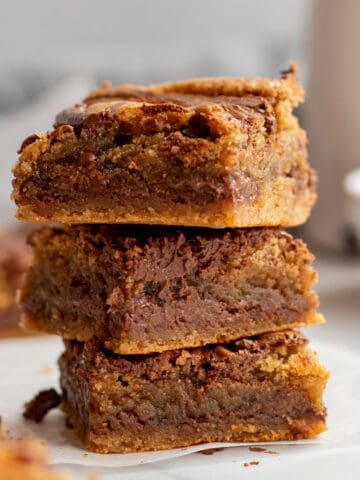 stack of 3 nutella blondies with white bowl and carafe in background