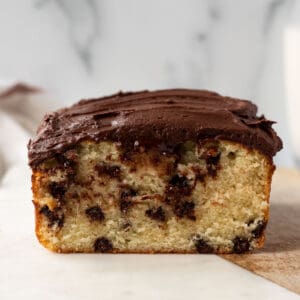 chocolate chip loaf cake frosted with whipped chocolate ganache sitting on a marble slab