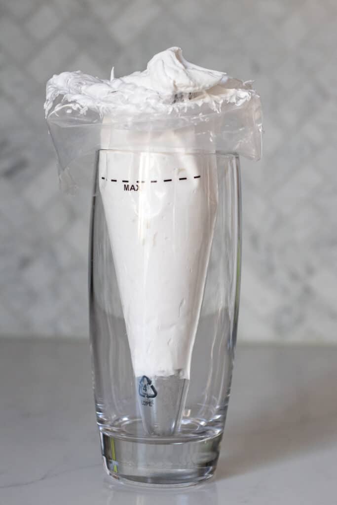 piping bag of meringue inside a glass 