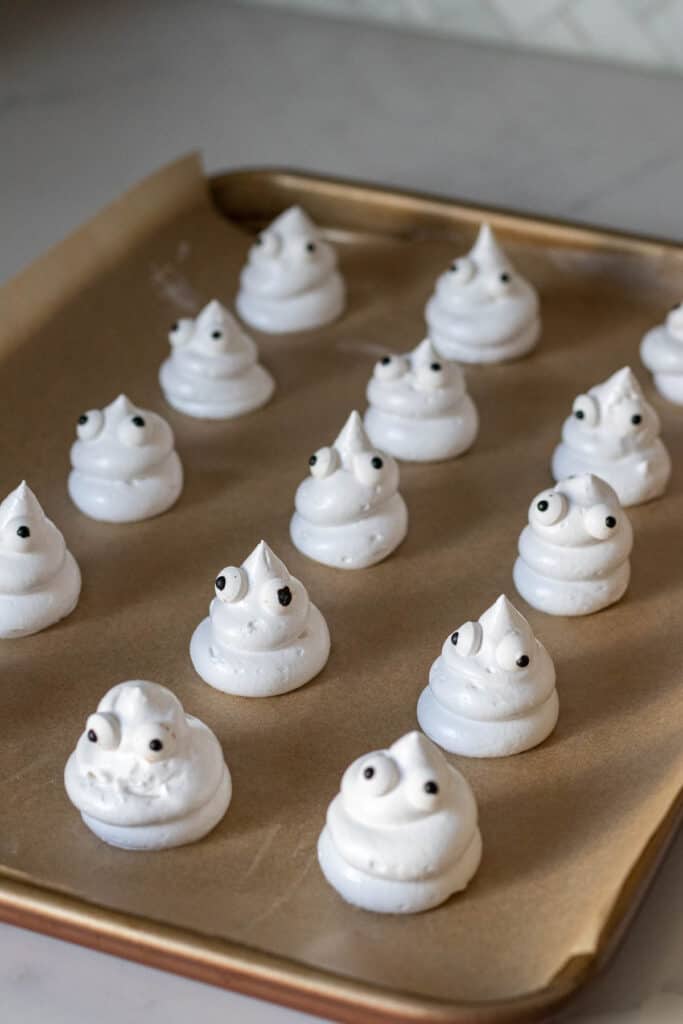 meringue ghosts on a sheet pan lined with parchment paper