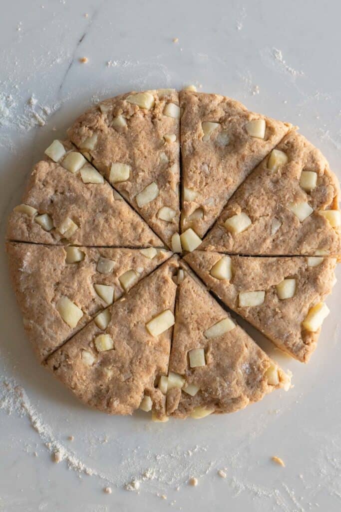 round disc of apple cinnamon scone dough cut into wedges