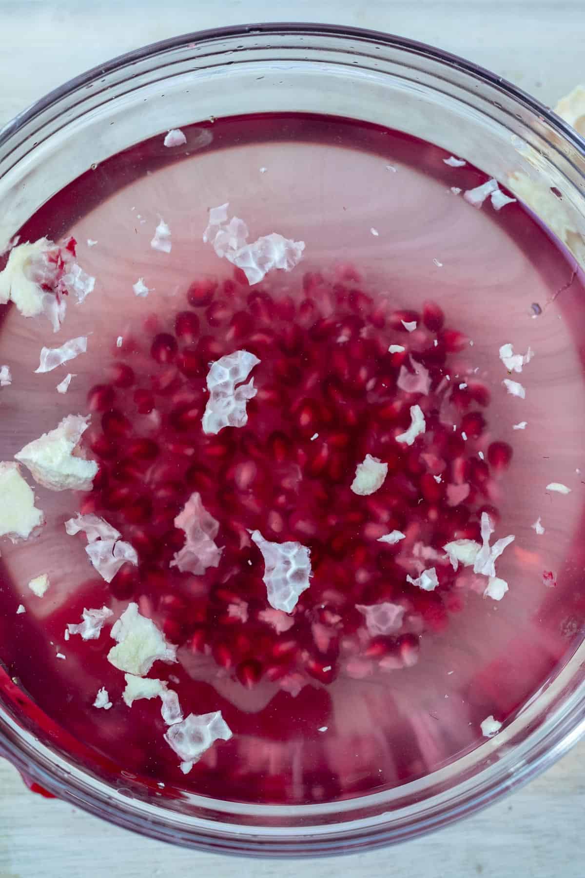 pomegranate seeds submerged in water