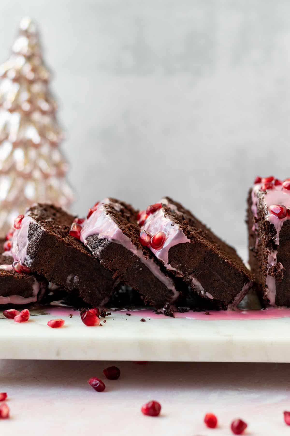 slices of chocolate loaf cake leaning onto each other on a marble board