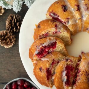 cranberry orange bundt cake slice and spread out on a marble cake stand